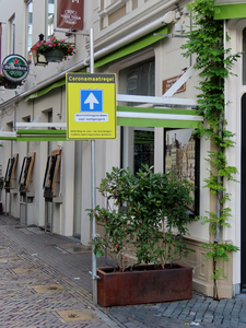 850264 Afbeelding van een waarschuwingsbord 'Coronamaatregel - éénrichtingverkeer voor voetgangers', bij de ingang van ...
